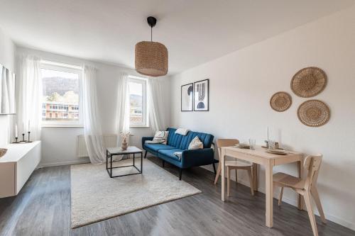 sala de estar con sofá azul y mesa en Modernes Apartment am Campus - Parken - Smart-TV - Kaffeevollautomat, en Wernigerode
