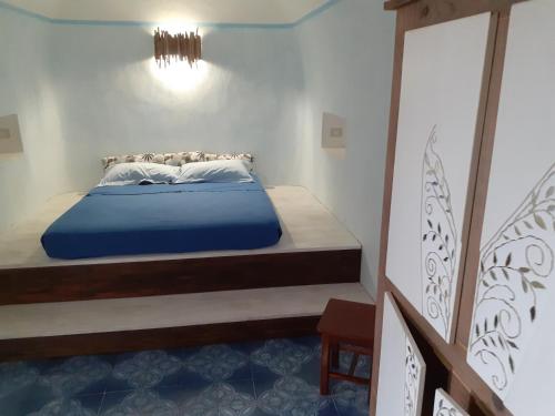 a bedroom with a blue bed in a room at Pantelleria 4 passi dal mare in Pantelleria