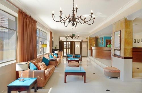 a living room with a couch and a chandelier at The Oceanic 1 bedroom with Ocean views - Self-catering Apartment in Durban
