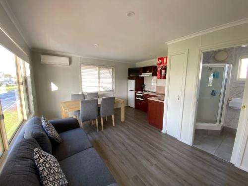 a living room and kitchen with a couch and a table at Christies Beach Tourist Park in Christies Beach