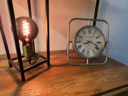 a clock on a table next to a lamp at Ferien Bungalow Ennens in Rhauderfehn