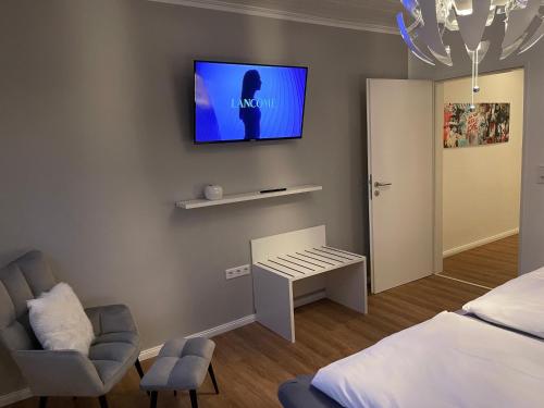 a bedroom with a bed and a tv on the wall at Ferien Bungalow Ennens in Rhauderfehn