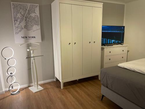 a bedroom with a bed and a white cabinet at Ferien Bungalow Ennens in Rhauderfehn
