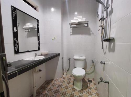 a bathroom with a toilet and a sink and a mirror at OYO 90784 Orkid Inn Kerteh in Dungun