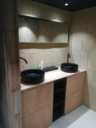 une salle de bain avec deux lavabos et un miroir dans l'établissement Bergerie en pleine nature (Grand Moulin), à Embres-et-Castelmaure