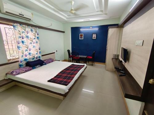een slaapkamer met een bed en een tafel en stoelen bij Sree Theja Residency in Anantapur