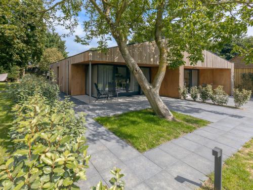 a house with a tree in front of it at De Duinlopers - Studio appt Bries - Strand, duinen en nabij cultuur steden in Castricum
