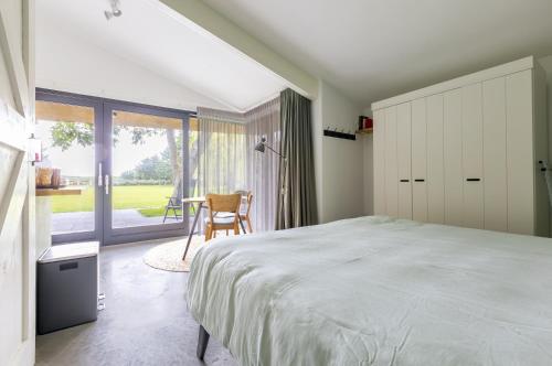 een slaapkamer met een bed, een tafel en een raam bij De Duinlopers - Studio appt Bries - Duinen, strand en nabij cultuur steden in Castricum