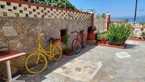 twee fietsen geparkeerd naast een stenen muur bij RafaelHouse in Chania