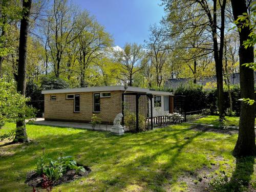 a small house in the middle of a yard at Veel eigen en omheinde grond in dit luxe huisje! in Wateren