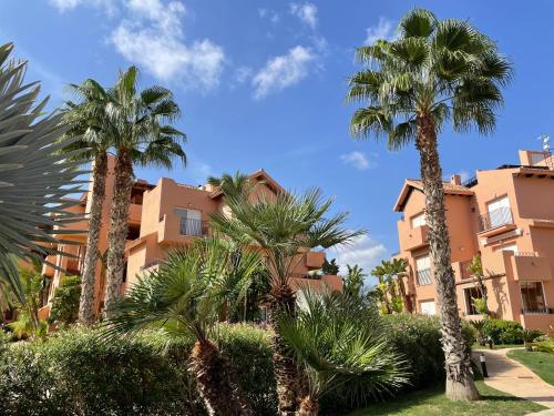 a group of palm trees in front of a building at Spirit of Mar Menor in Torre-Pacheco