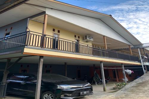 a car parked in front of a house with a balcony at SPOT ON 92544 Senja Homestay in Balikpapan