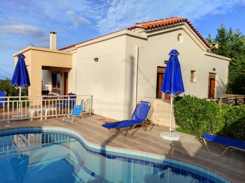 a villa with a swimming pool in front of a house at Helidonia Villas in Pigi