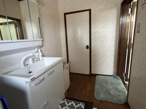 Łazienka z umywalką i drzwiami z lustrem w obiekcie 天満の宿不知火 w mieście Uki