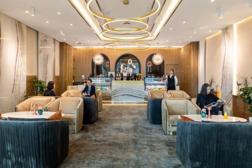 a lobby of a restaurant with people sitting at tables at Novotel Ulaanbaatar in Ulaanbaatar