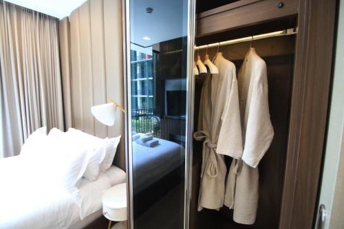 a bedroom with a bed and a closet with towels at Execlusive Suite 209 by Forest Khaoyai in Ban Huai Sok Noi