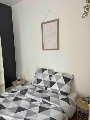 1 dormitorio con cama estampada en blanco y negro en La douce chambrée de Guingamp en Guingamp