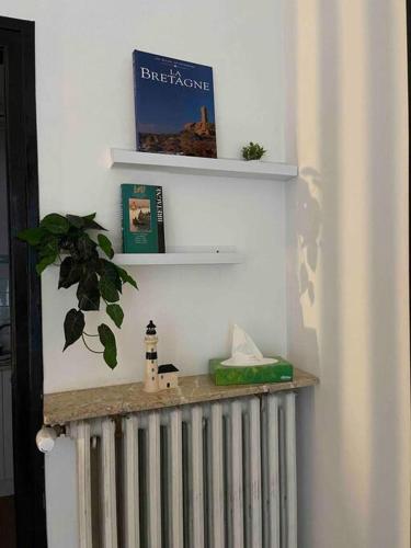 a radiator in the corner of a room with a book at La douce chambrée de Guingamp in Guingamp