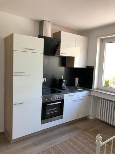 a kitchen with white cabinets and a stove at Mini Appartement Messezimmer Nähe Düsseldorf, Appartement 25 qm Hilden in Hilden