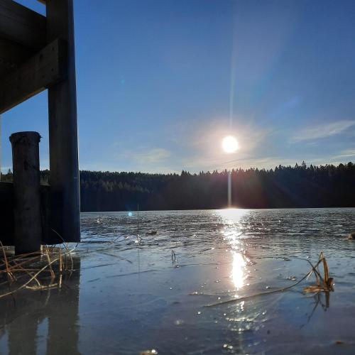 a large body of water with the sun in the sky at Rosa's stuga in Tasebo