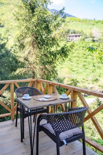 a table and chairs on a wooden deck with a view at Montana Suite Bungalows in Trabzon