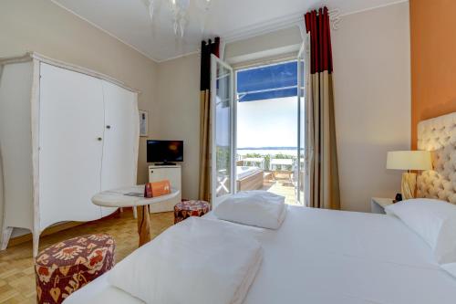 a hotel room with a bed and a large window at Hotel Flaminia in Sirmione