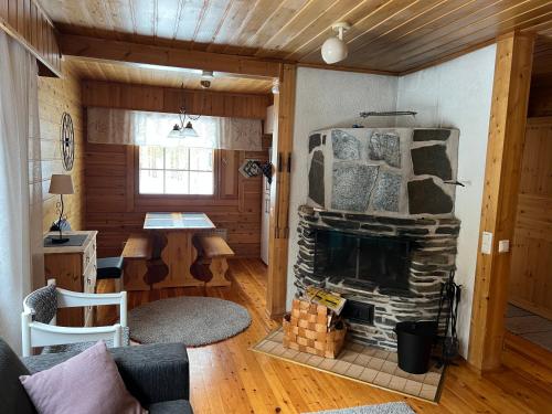 a living room with a stone fireplace in a house at Susitupa 5 in Salla