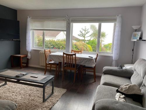uma sala de estar com uma mesa e um sofá em No12 Pats Place - Sleeps 6 - Sea views over Carbis Bay em Carbis Bay