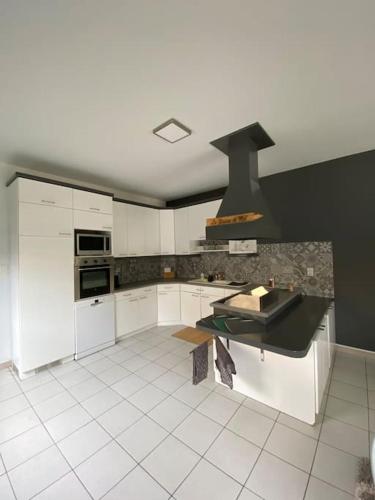 a kitchen with white cabinets and a black stove at La Maison de Mel in Bois le Duc