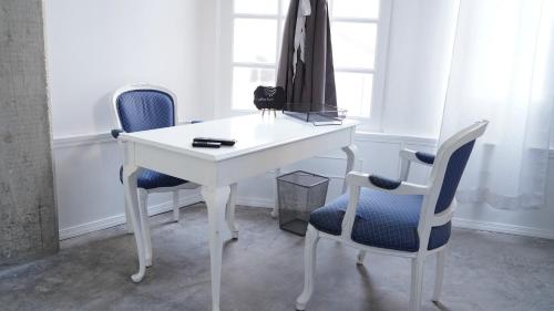 a white desk with two chairs and a table at Estudio Central London Consulado in Tijuana