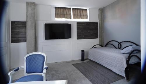 a bedroom with a bed and a tv and a chair at Estudio Central London Consulado in Tijuana