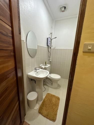 W łazience znajduje się umywalka, toaleta i lustro. w obiekcie Elisha's Guest House w mieście Coron