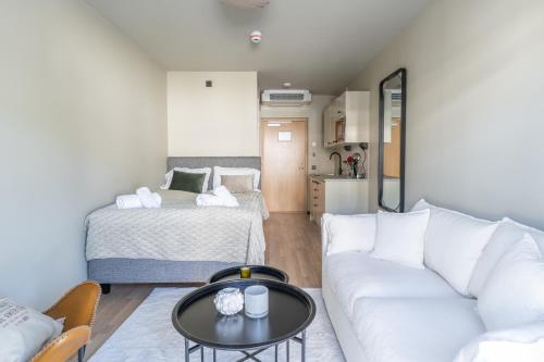ein Wohnzimmer mit einem Sofa und einem Bett in der Unterkunft Hotell Hanöhus Hällevik in Sölvesborg