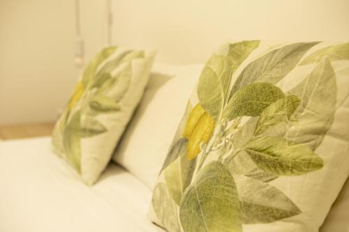due cuscini con foglie su un letto di Alojamientos Cantíber a Santander