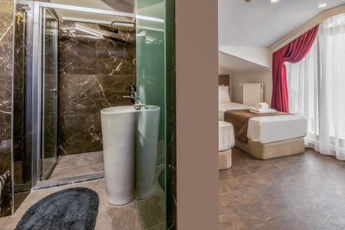 a bathroom with a shower and a tub in a room at Baymari Suites Design Florya in Istanbul