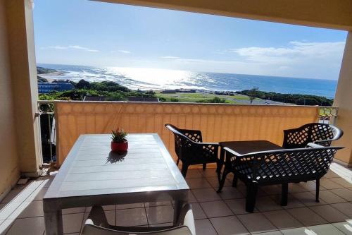 una mesa y sillas en un balcón con vistas al océano en Breathtaking View of the Blues en Margate
