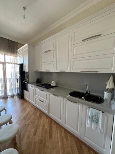 a kitchen with white cabinets and a sink at Luxury seaside home in Sumqayyt