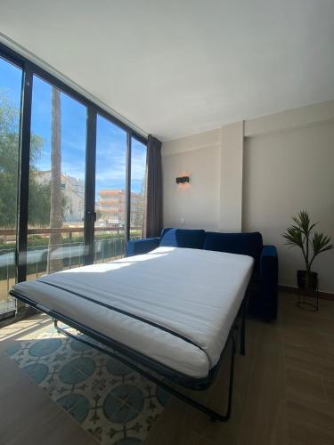 a large bed in a room with a large window at Studio Don Jim Family, Beautiful luxurious new Studio near Arenal beach in Jávea