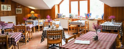 un ristorante con tavoli e sedie con controlli rossi e bianchi di AU CHAT BLEU a Saint-Laurent-les-Bains