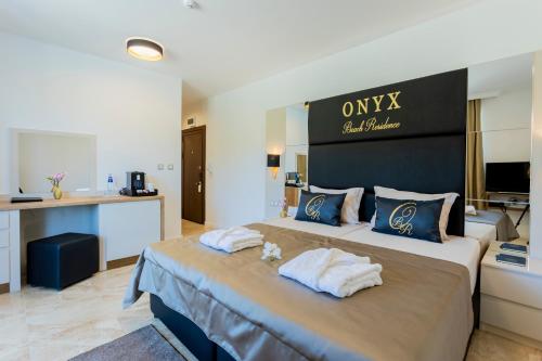 a hotel room with two beds with towels at Onyx Beach Residence - Free Parking & Beach Access in Sveti Vlas