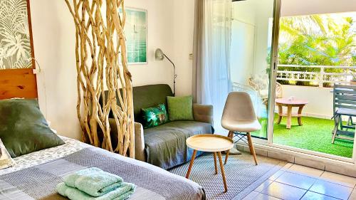 a bedroom with a bed and a couch and a window at Calm & Cosy, magnifique T1 proche CHU in Saint-Pierre