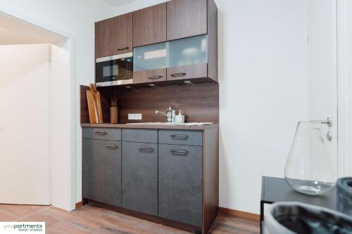 eine Küche mit einer Spüle und Holzschränken in der Unterkunft Aasee Apartment in top Lage 80m² mit 2 Schlafzimmern in Münster