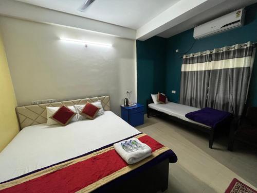 a bedroom with two beds and a window at Hotel Shivanand in Siliguri