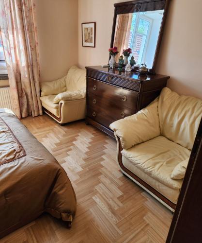 a bedroom with a couch and a dresser and a mirror at HaPPy Inn ArkA the heart of Old Town, Self-Check-in, A-C, Car-Parking, Balkony in Vilnius