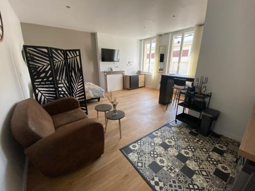 a living room with a couch and a piano at Brown Cosy in Louviers