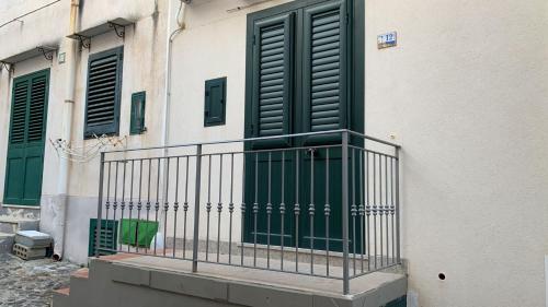 un edificio con una puerta verde y un balcón en Casa Spaziosa al centro di Ustica, en Ustica
