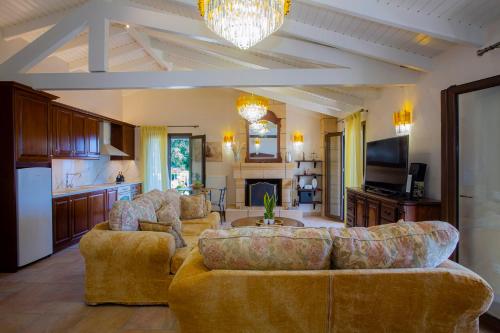 ein Wohnzimmer mit 2 Sofas und einer Küche in der Unterkunft Solaris Methea- Luxury Central Villa by the Castle in Kassiopi