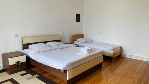 two beds in a room with wooden floors at Lia's Guest House in Sighnaghi