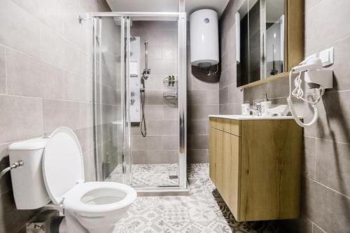 a bathroom with a shower and a toilet and a sink at KNL luxury apartment by homebrain in Alexandroupoli