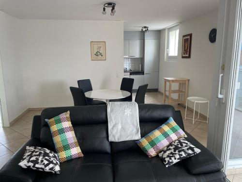 a living room with a black couch and a table at Appartamento 464 nel CUORE di Locarno con piscina in Locarno
